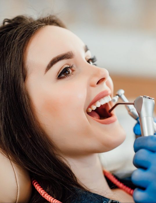 Mulher fazendo limpeza nos dentes.